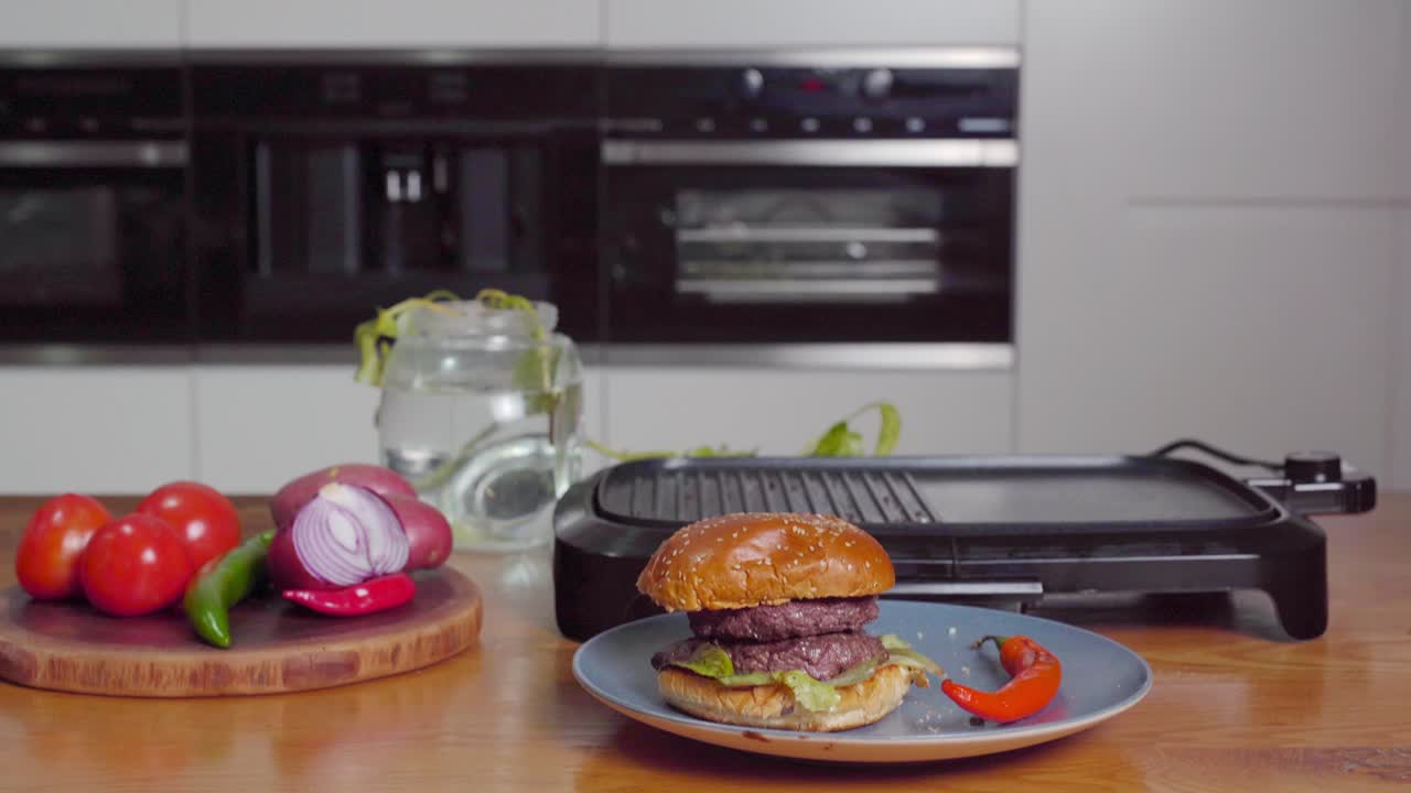 бургер скользит в кадр с электрической грилью на заднем плане