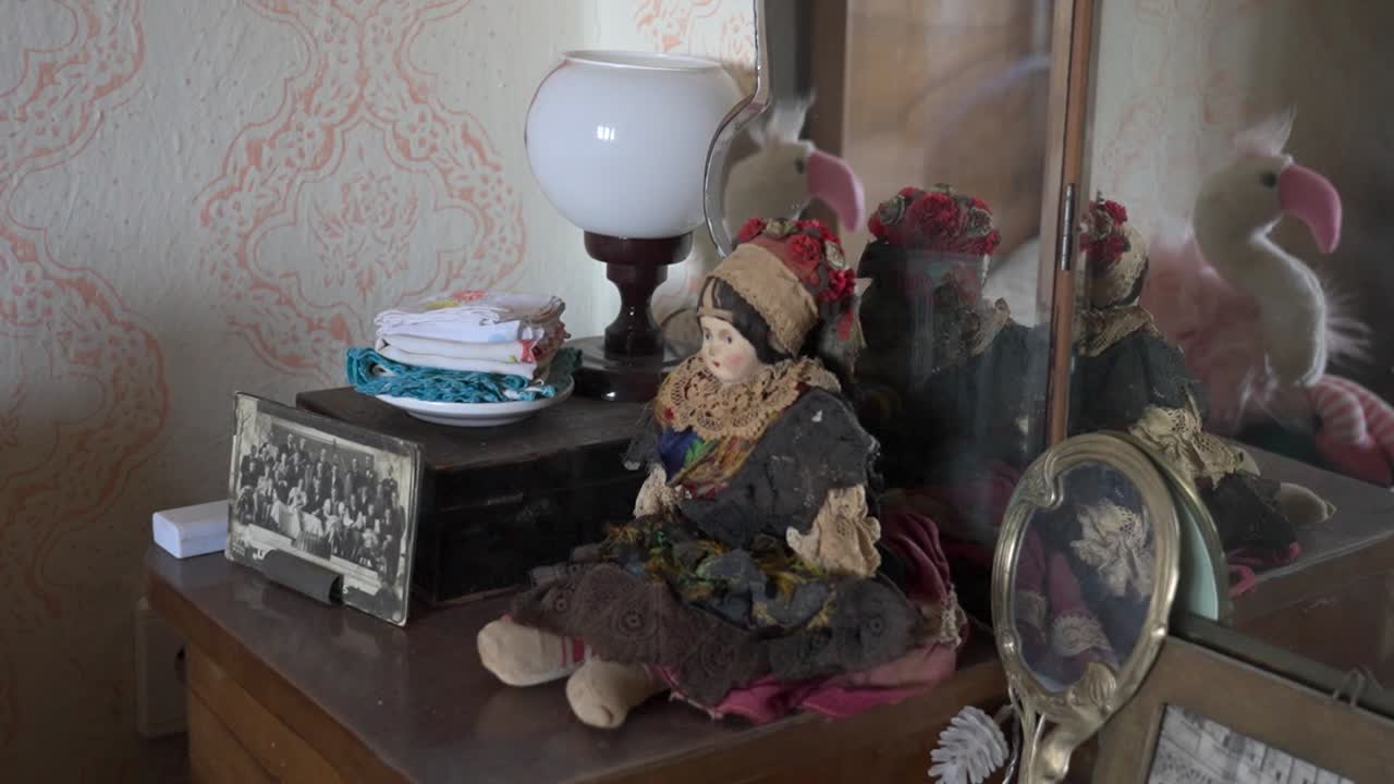 Traditional doll sitting on antique wooden dresser indoors