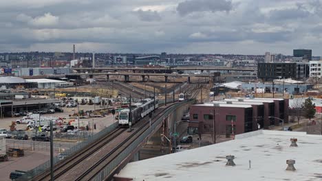 transporte público sistema ferroviario de tranvía se eleva en el puente en un día nublado en las afueras de la ciudad de denver