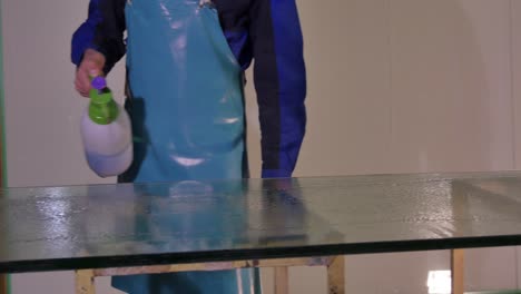 cleaning a large glass surface with a spray bottle