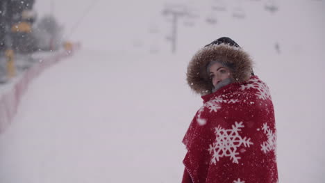 close up of frozen woman wrapped in a blanket at snowstorm 3