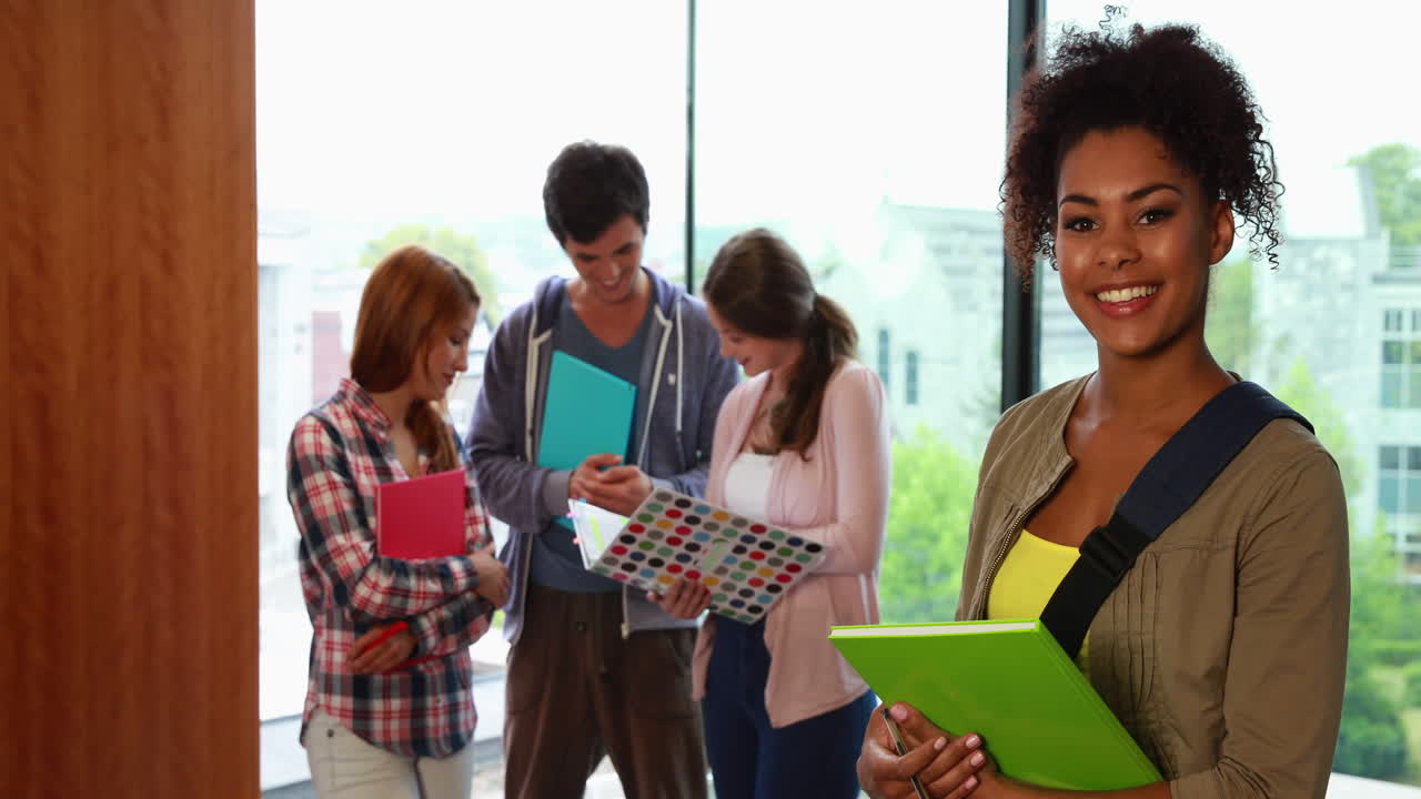 estudiante sonriendo a la cámara en la biblioteca