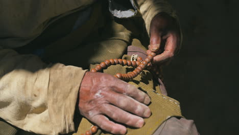 nepali old sherpa buddhist man counting tibetian prayer beads at upper mustang nepal