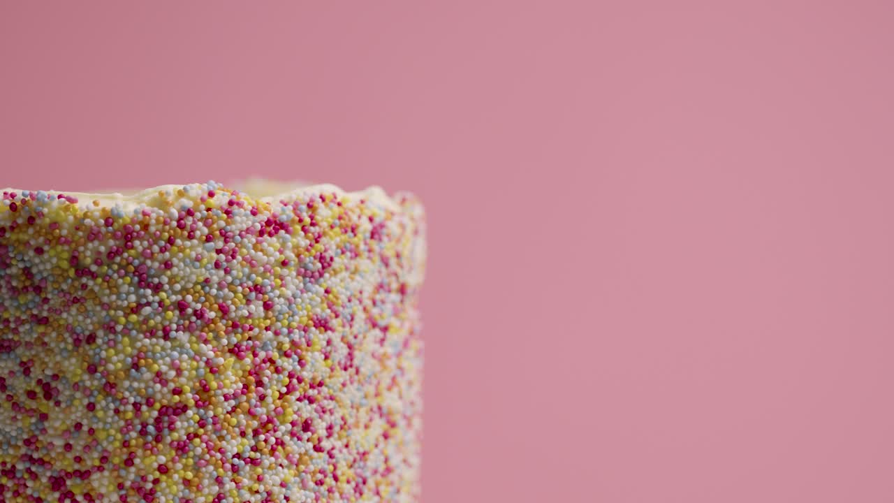 primer plano de estudio de pastel de cumpleaños giratorio cubierto con cientos y miles de decoraciones 1