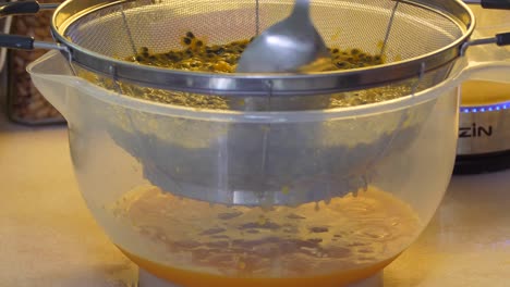 stirring the passion fruit pulp to separate the juice