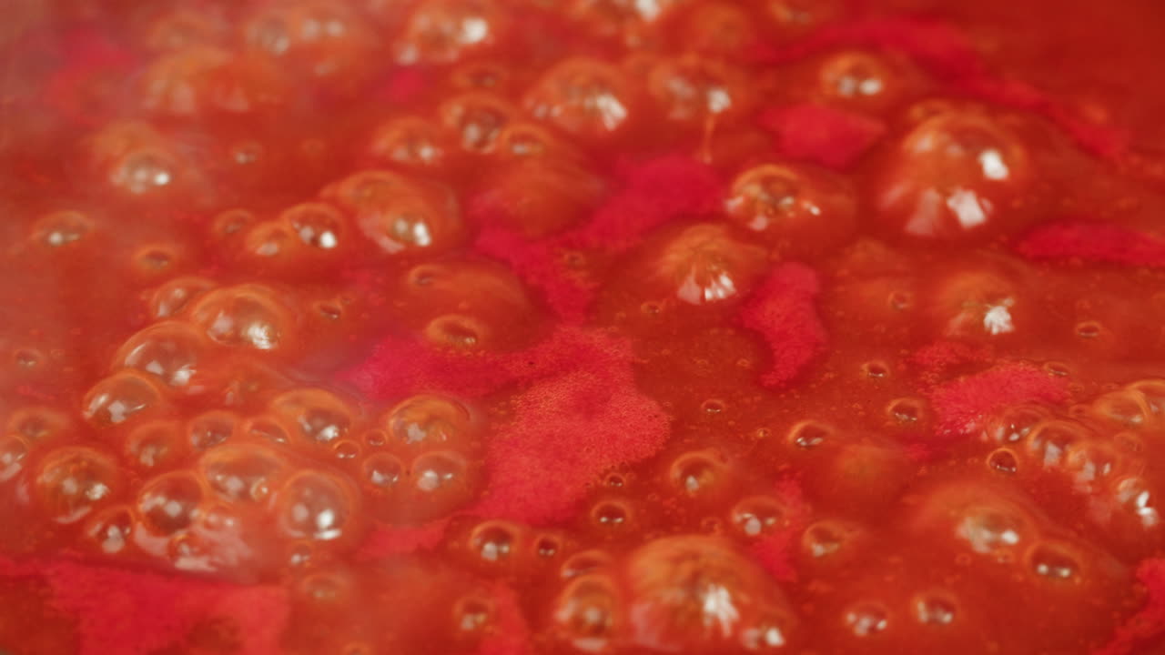 Chicken in tomato sauce is boiling on a frying pan with spices. Cooking tomato sauce curry with chicken fillet. Traditional Italian Mexican Asian dish. High quality studio shot for cafe, restaurant close up.