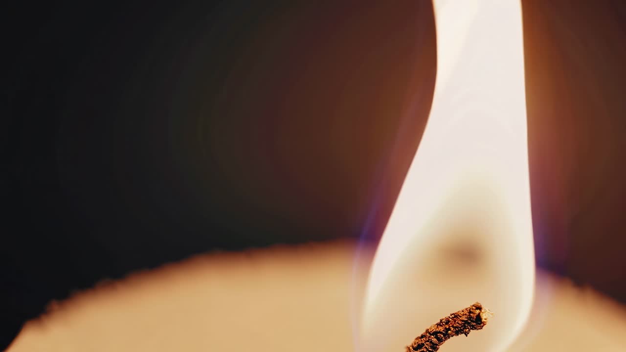 Close-up video shot of a candle flame, captured from a low angle