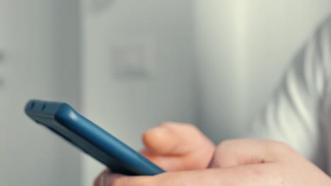 joven de primer plano utiliza el teléfono inteligente trabajando desde