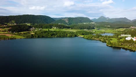 Gleitende-Landschaftsaufnahme-Aus-Der-Luft-Von-Der-Küste-Des-Velenjsko-Sees-Mit-Hügeln-Im-Hintergrund-Slowenien-Europa