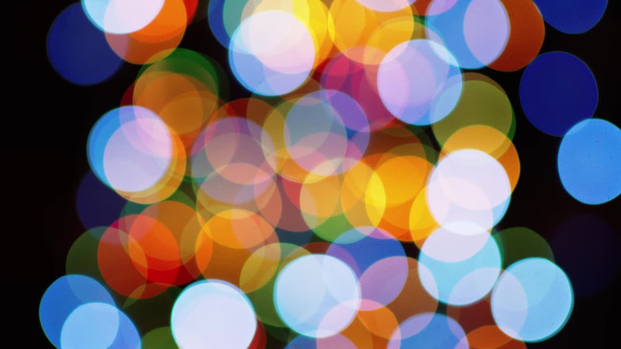 bokeh parpadeante multicolor sobre un fondo negro.