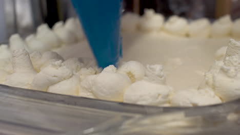 close up view of baker applying fresh cream using piping bag to tiramisu desert cake