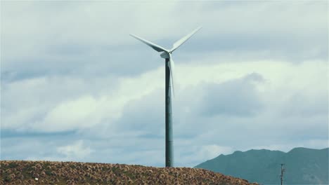 windmill for energy production on beautiful cloudy sky at highland