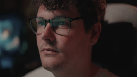 close-up of a man wearing glasses, looking attentively