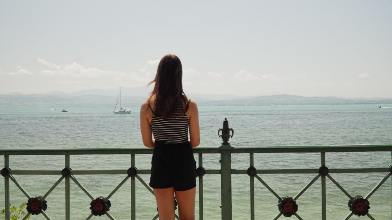 Woman Walks Up to Pier to Overlook Lake Constance Bodensee in Friedrichshafen, Germany