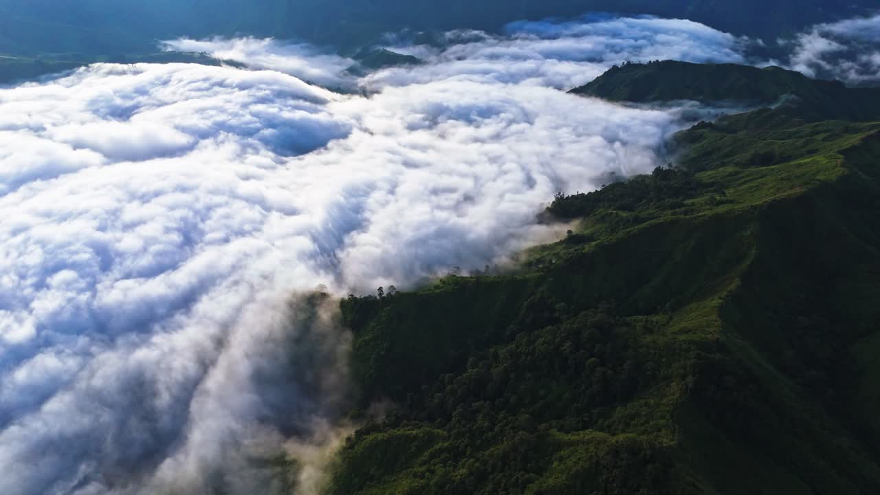 Cinematic 4K aerial of dramatic clouds rolling over lush green mountain peaks. Perfect for nature films, travel promos, documentaries, and inspirational cinematic projects