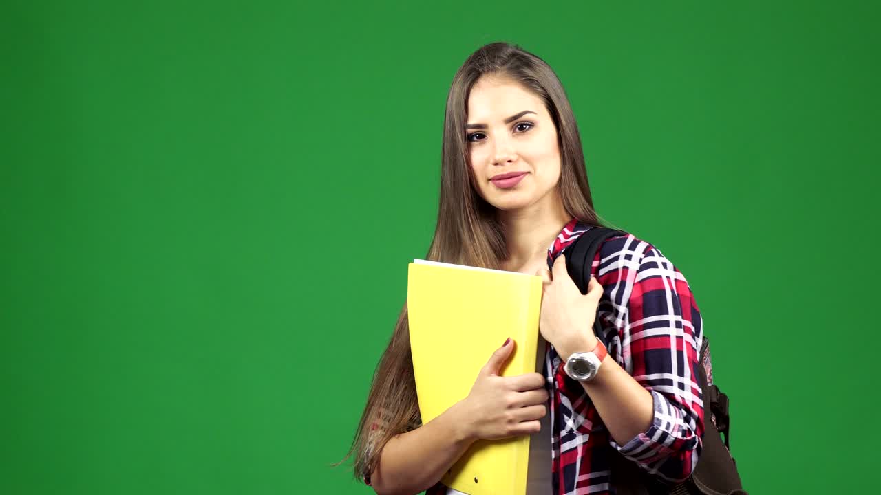 Young beautiful female student with a backpack smiling to the camera