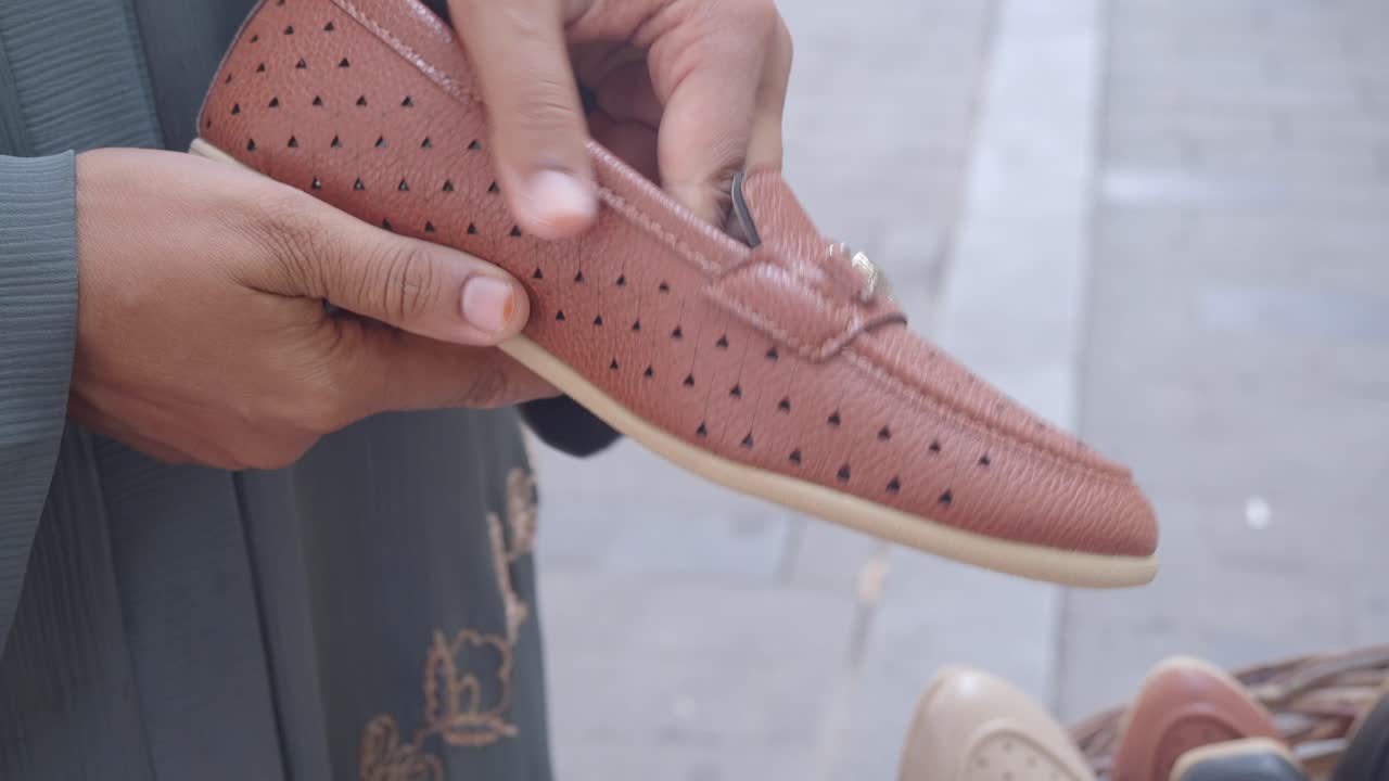 손에 갈색 신발 한 을 들고 있는 여자