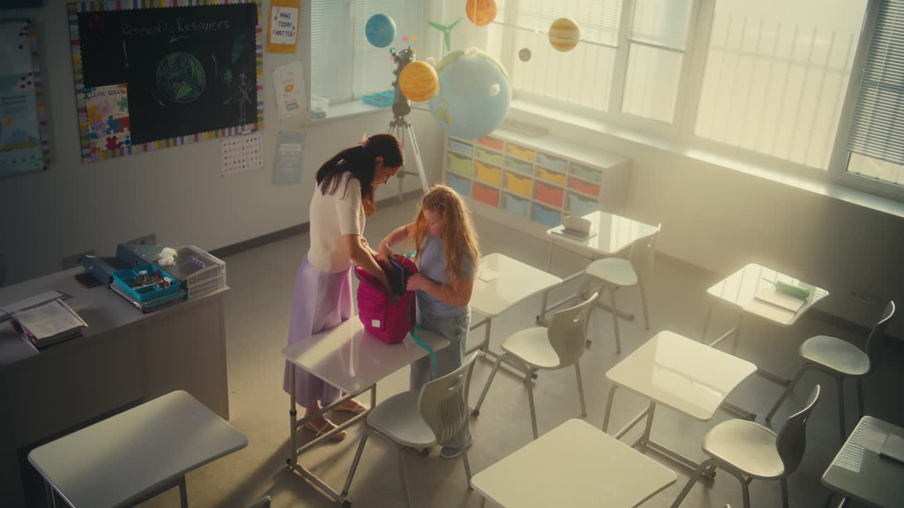 End of the School Day Female Teacher Helping the Girl to Pack Her School Supplies