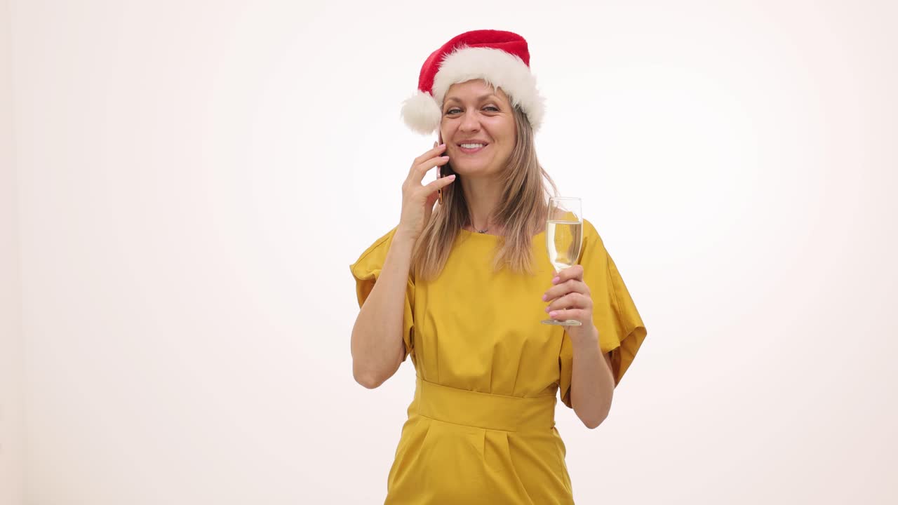 Woman in Santa Hat with Champagne and Phone