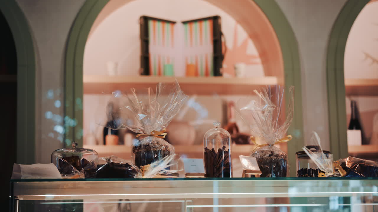 Packaged desserts and jars arranged neatly on glass shelves in a stylish bakery