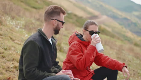 couple hiking and enjoying a drink in the mountains