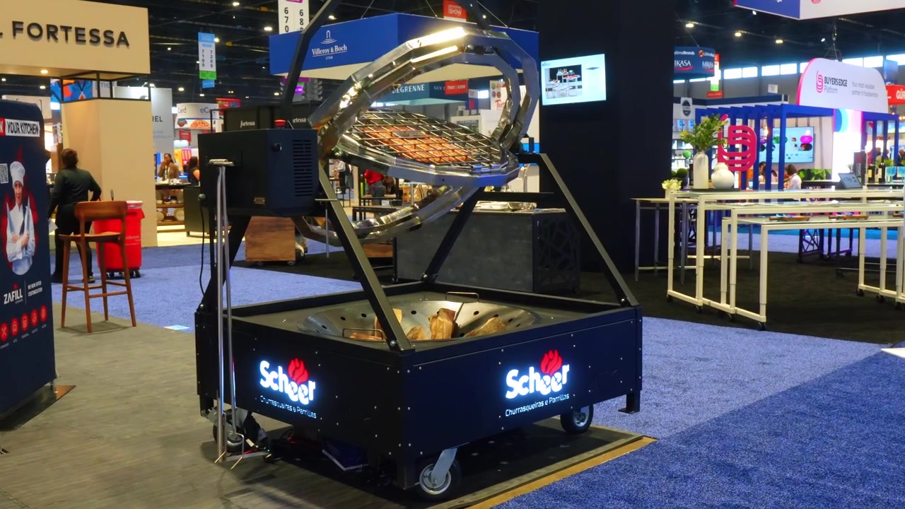 Chicago, USA, 27. Mai 2026 : Rotisserie-Grill ausgestellt auf der Fachmesse für Restaurantbedarf in Chicago. Ein Bratenkorb aus Stahl und eine Brennkammer stehen auf Rädern in einer Messehalle.