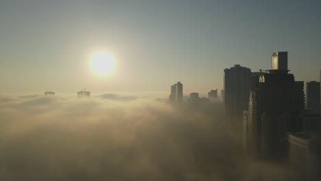 Vista-Aérea-De-La-Niebla-Sobre-Sharjah,-El-Horizonte-De-Sharjah-Cubierto-Por-La-Niebla-De-La-Mañana-De-Invierno,-Emiratos-árabes-Unidos,-Imágenes-De-Drones-De-4k