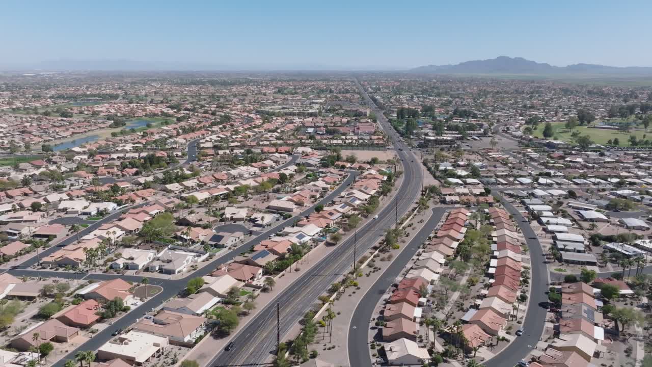 아리조나 주 고속도로를 따라 럭셔리 빌라가 있는 미국 주택 지역 - 피닉스 메트로폴리스 근처의  호수 - 지붕에 현대적인 태양 전지판을 설치하여 녹색 에너지를 생산하고 - 도로에서 자동차를 운전합니다.