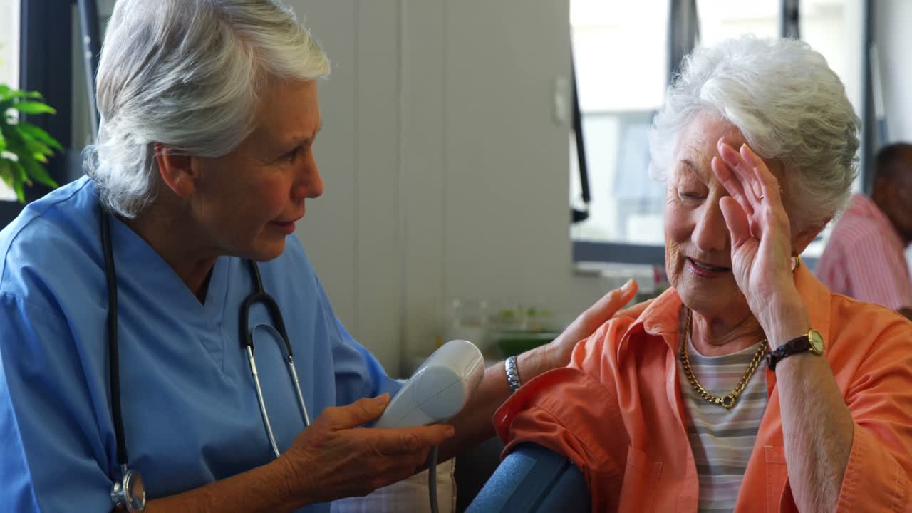 Female doctor checking blood pressure of senior woman 4k
