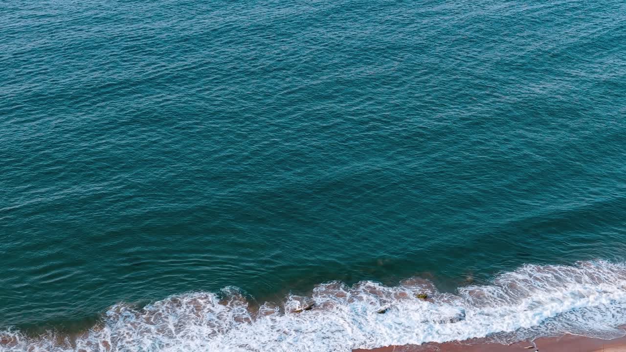 Onde che si infrangono sulla riva in Portogallo al tramonto vicino alla spiaggia