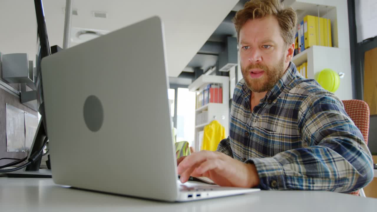 Männlicher Architekt arbeitet mit Laptop am Schreibtisch 4K