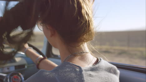 beautiful-girl-driving-vintage-car-on-road-trip