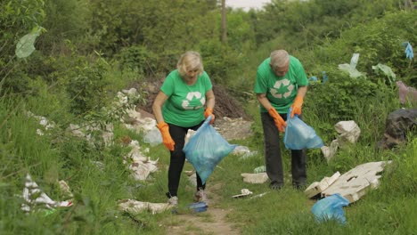 Volunteer-team-cleaning-up-dirty-park-from-plastic-bags,-bottles.-Reduce-trash-cellophane-pollution