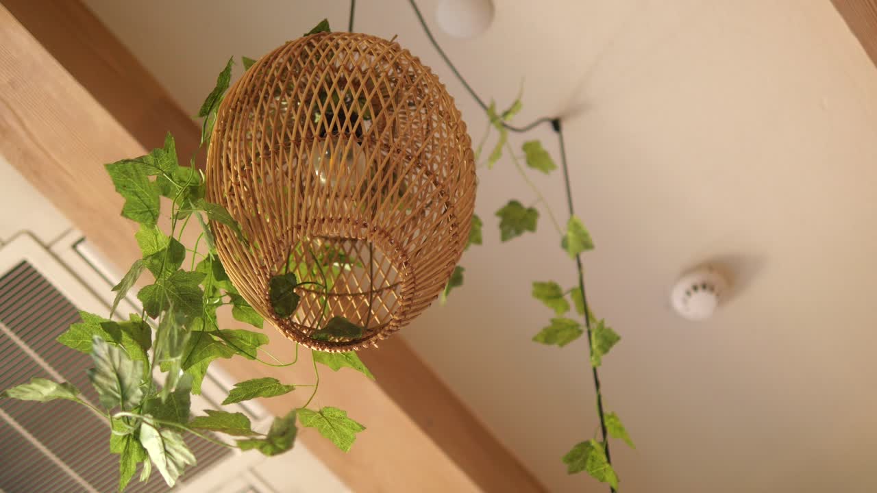 Pendant light with wicker shade and decorative leaves