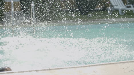 young boy and girl jumping into swimming pool from poolside.