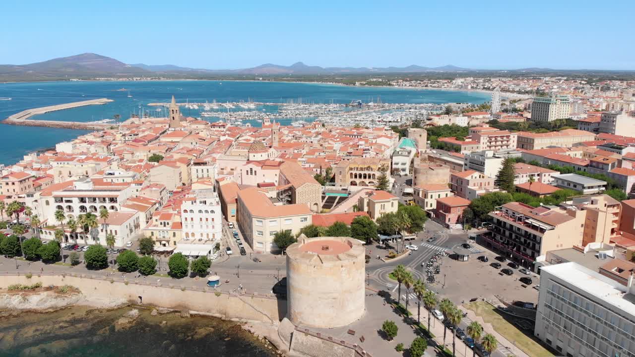 Letecký dron horizontálně panoramaticky snímá staré město Alghero podél pobřeží