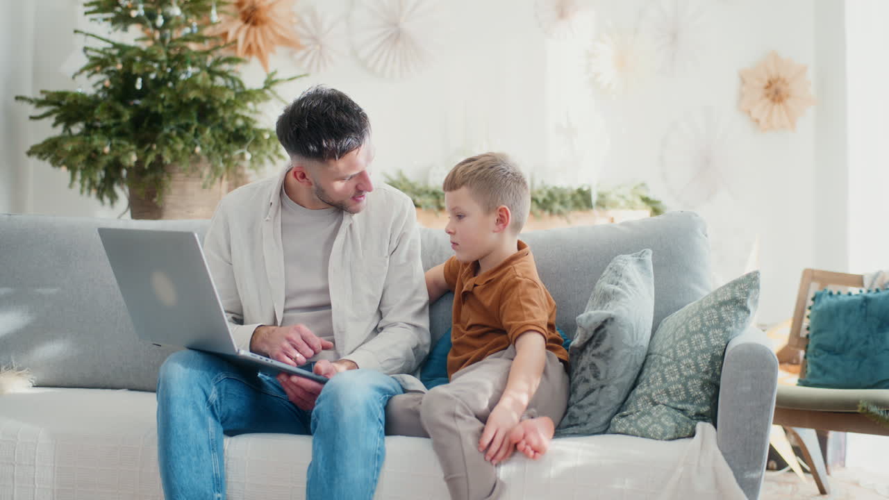 padre y hijo joven comprando en línea en la computadora portátil