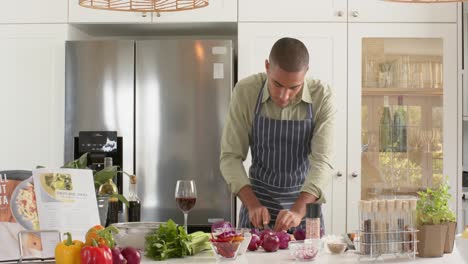 Biracial-male-cooking-vlogger-in-apron-talking-and-filming-in-kitchen