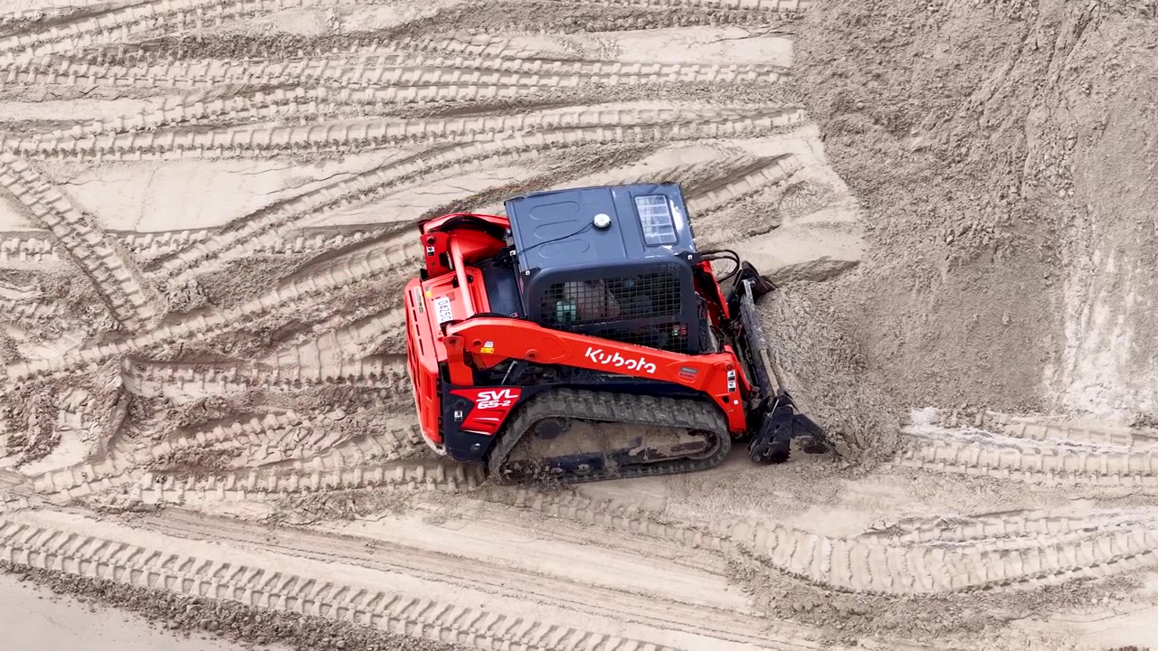 Aerial View of Red Kubota Compact Track Loader Pushing Sand