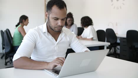 Ernsthafter-Junger-Mann,-Der-Auf-Dem-Laptop-Tippt.