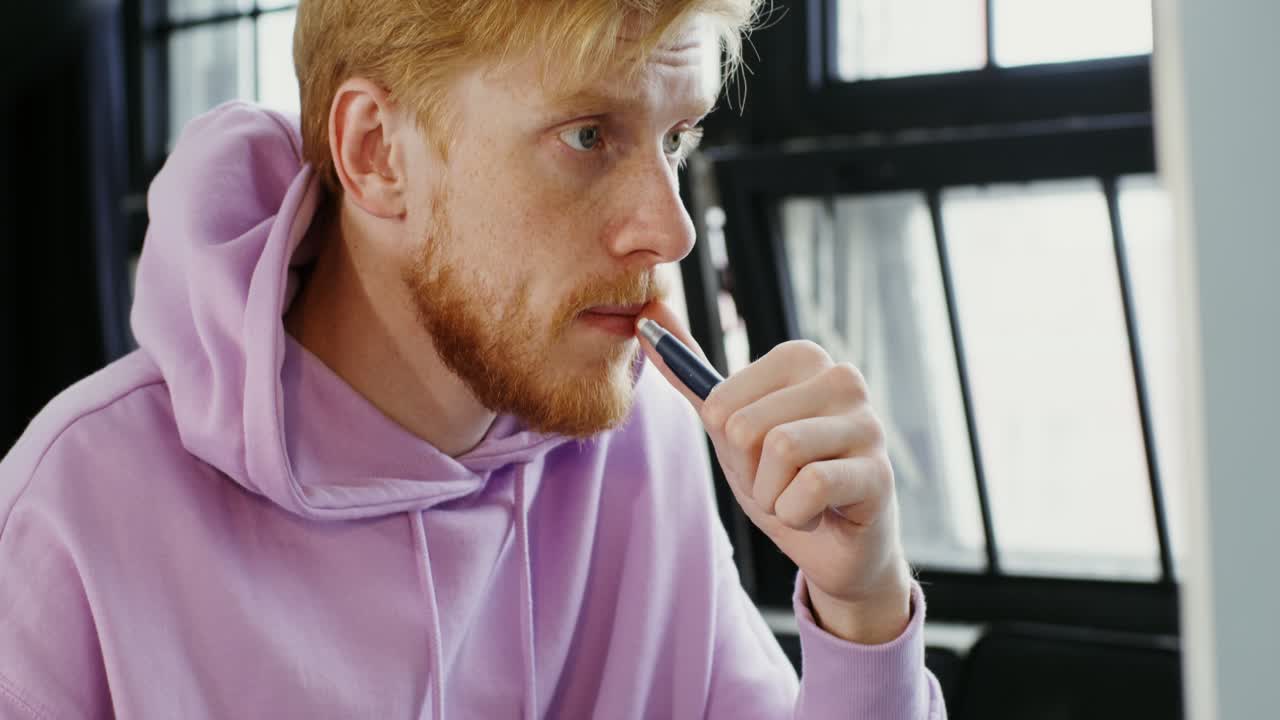 hombre con capucha púrpura trabajando en la computadora