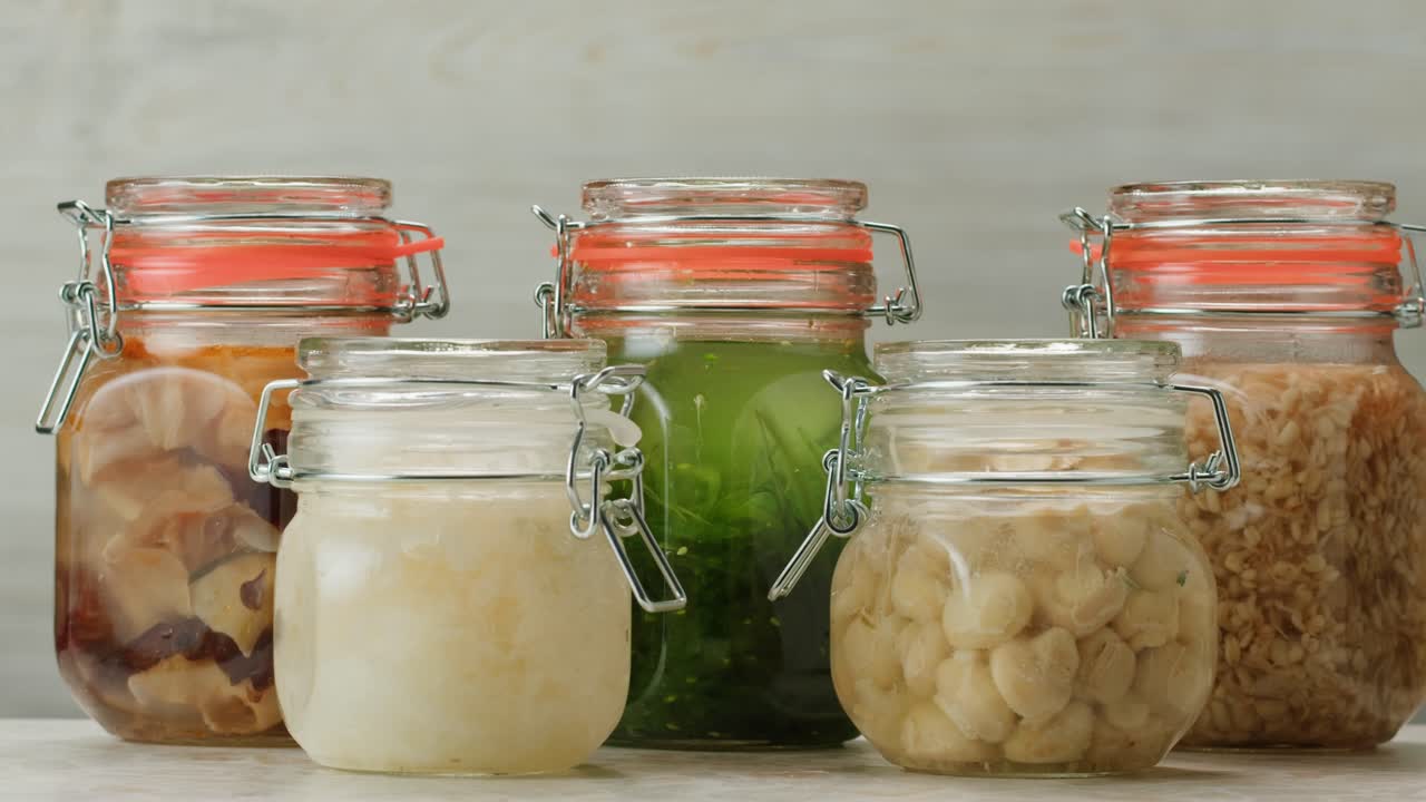 Fermented champignons, Jar with marinated mushrooms on wooden table, traditional salted marinated asian food.
