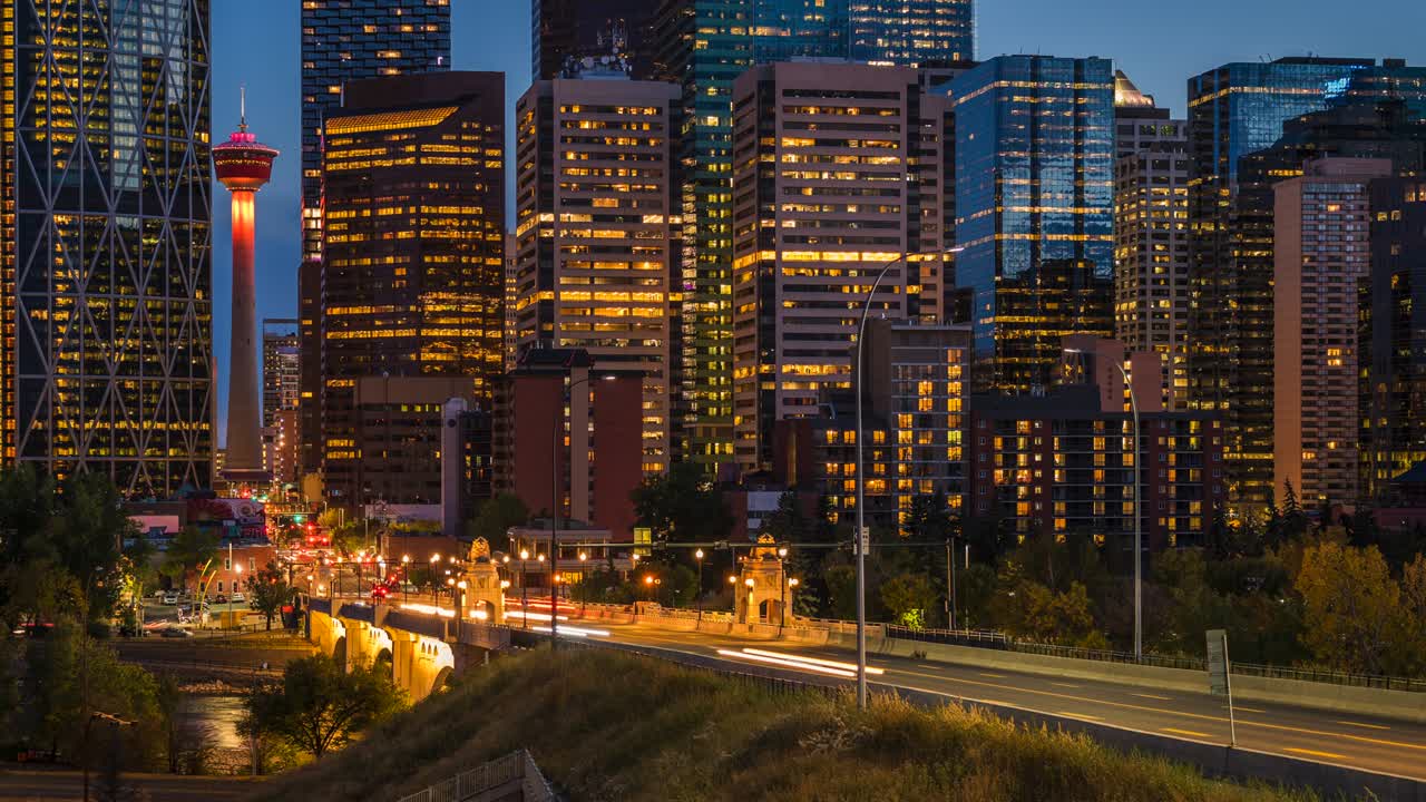 vista en lapso de tiempo de edificios modernos de gran altura y tráfico en la hora pico en el centro de calgary, alberta, canadá, alejar el zoom