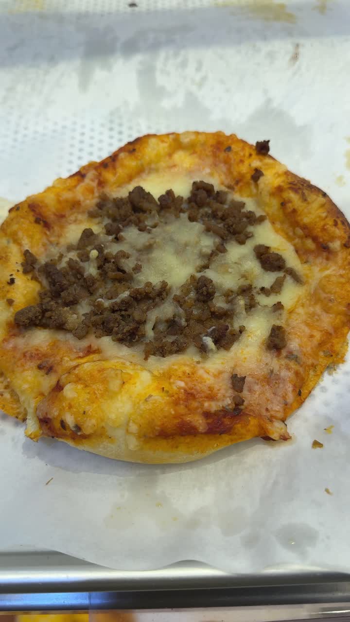 Pizzetta appena sfornata con carne macinata e formaggio fuso
