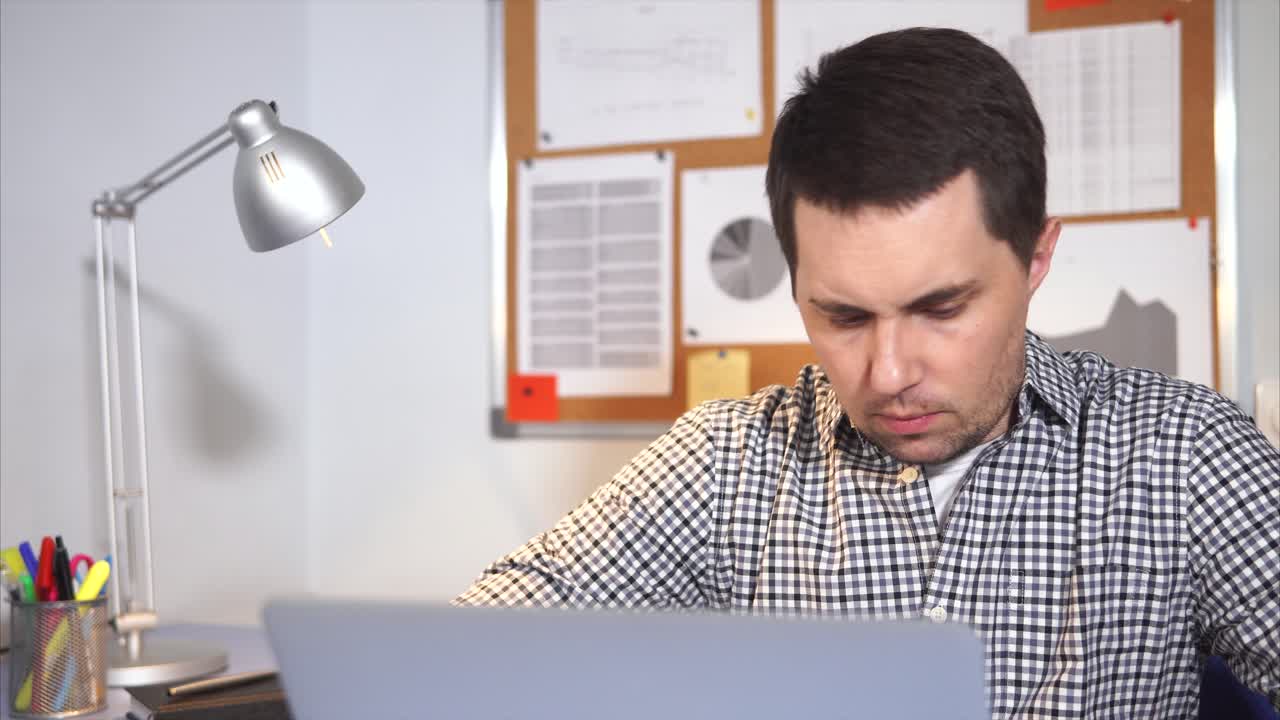 Hombre que trabaja en la computadora portátil en la oficina