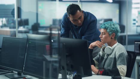 trabajo en equipo en una oficina diversa: el gerente de proyecto habla con un especialista en soluciones creativas, discuten el diseño, se muestra una computadora de escritorio. los profesionales crean contenido moderno, comercio electrónico, estrategia de redes sociales