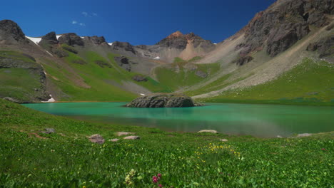 Aerial-cinematic-drone-Ice-Lake-Basin-Silverton-Island-Lake-aqua-blue-clear-water-alpine-tundra-stunning-mountain-range-wildflowers-mid-summer-daytime-bluesy-beautiful-slow-slider-left-movement