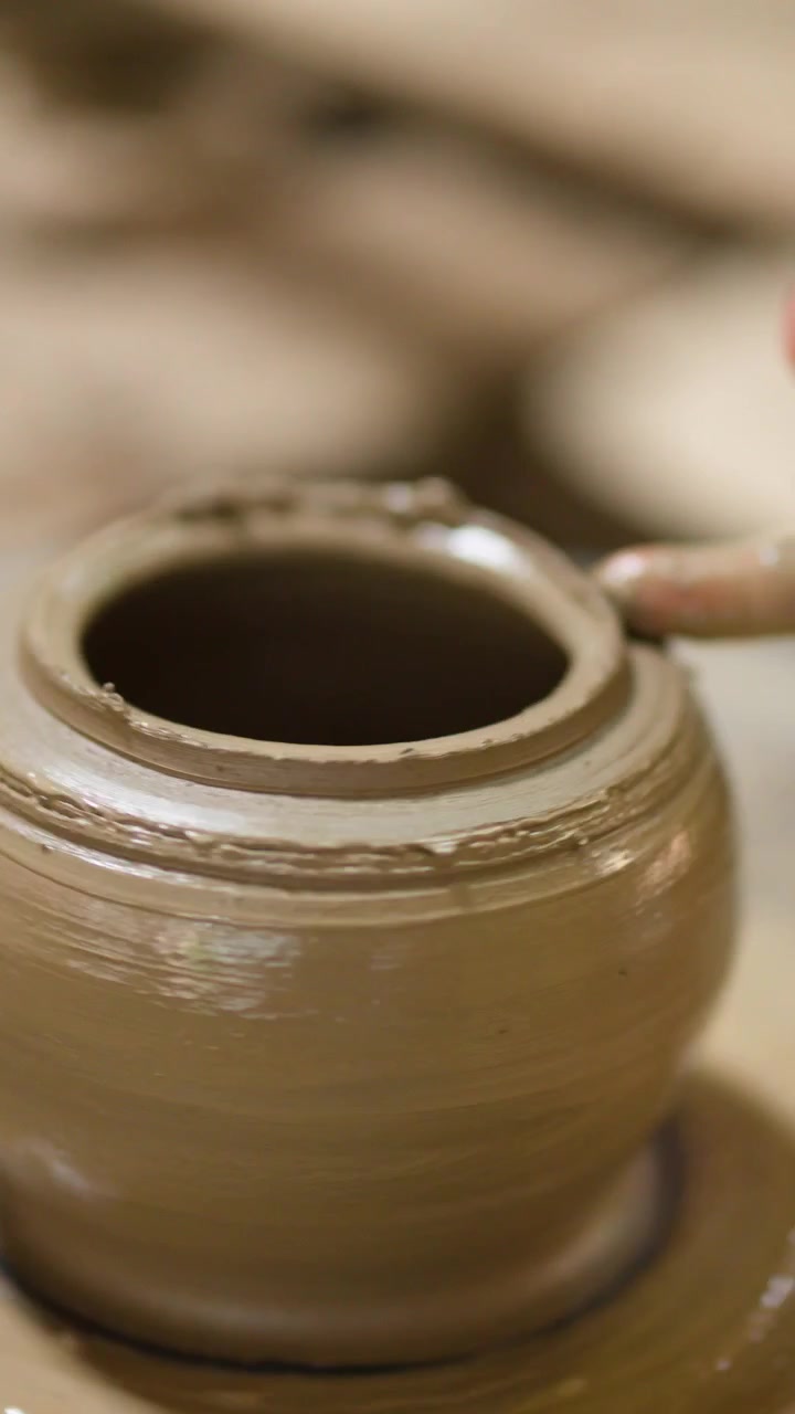 Primo piano di mani che modellano un vaso di argilla bagnata su un tornio in Thailandia
