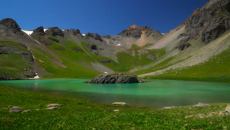 Aéreo-Cinematográfico-Zumbido-Hielo-Lago-Cuenca-Isla-Silverton-Lago-Agua-Azul-Agua-Clara-Tundra-Alpina-Impresionante-Cordillera-Flores-Silvestres-Mediados-De-Verano-Durante-El-Día-Azul-Dky-Hermoso-Quieto-Natural-Movimiento