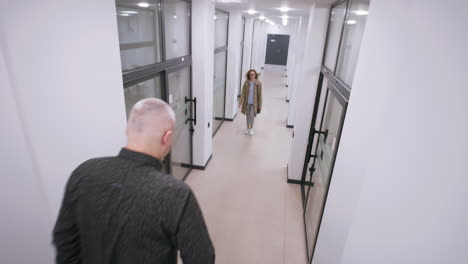 people walking and interacting in a modern office hallway